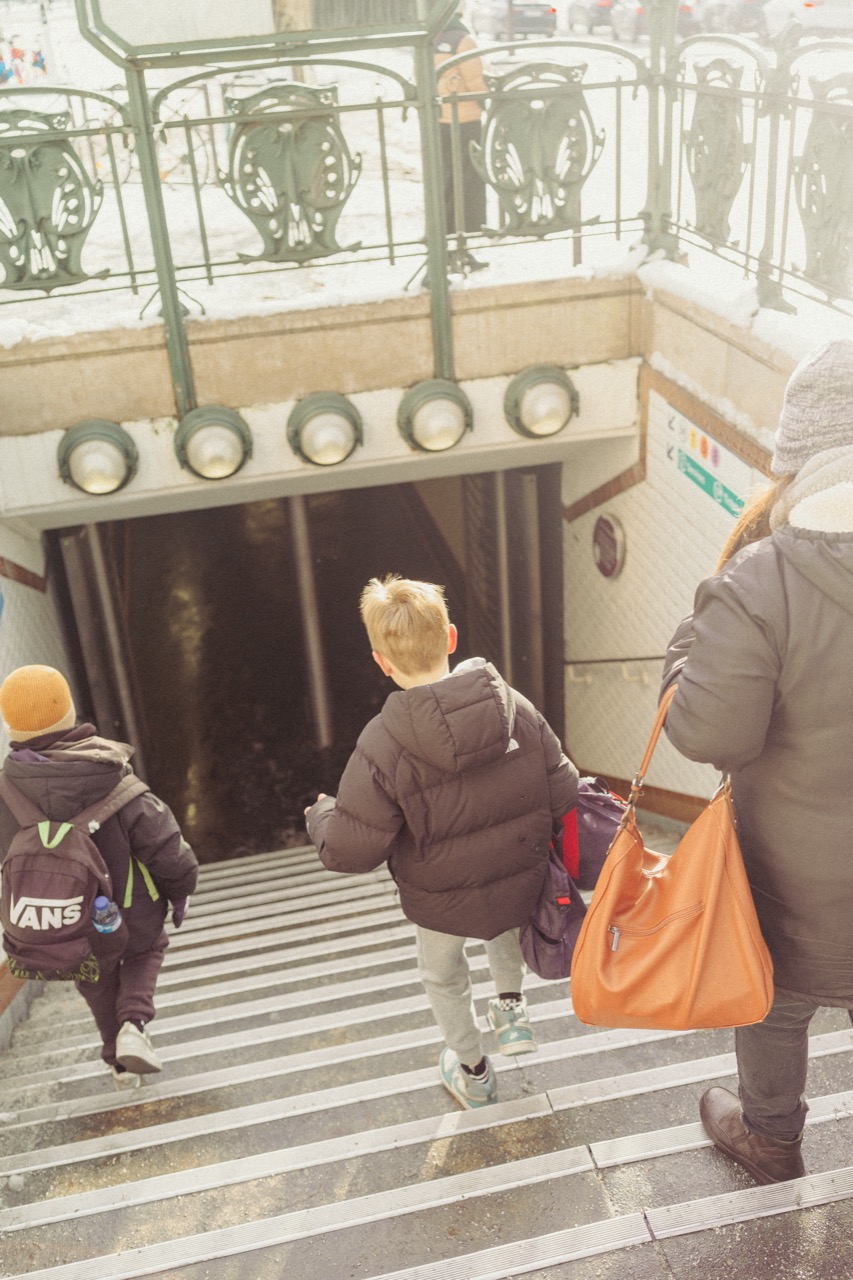 Parent and children descending Metro stairs in winter